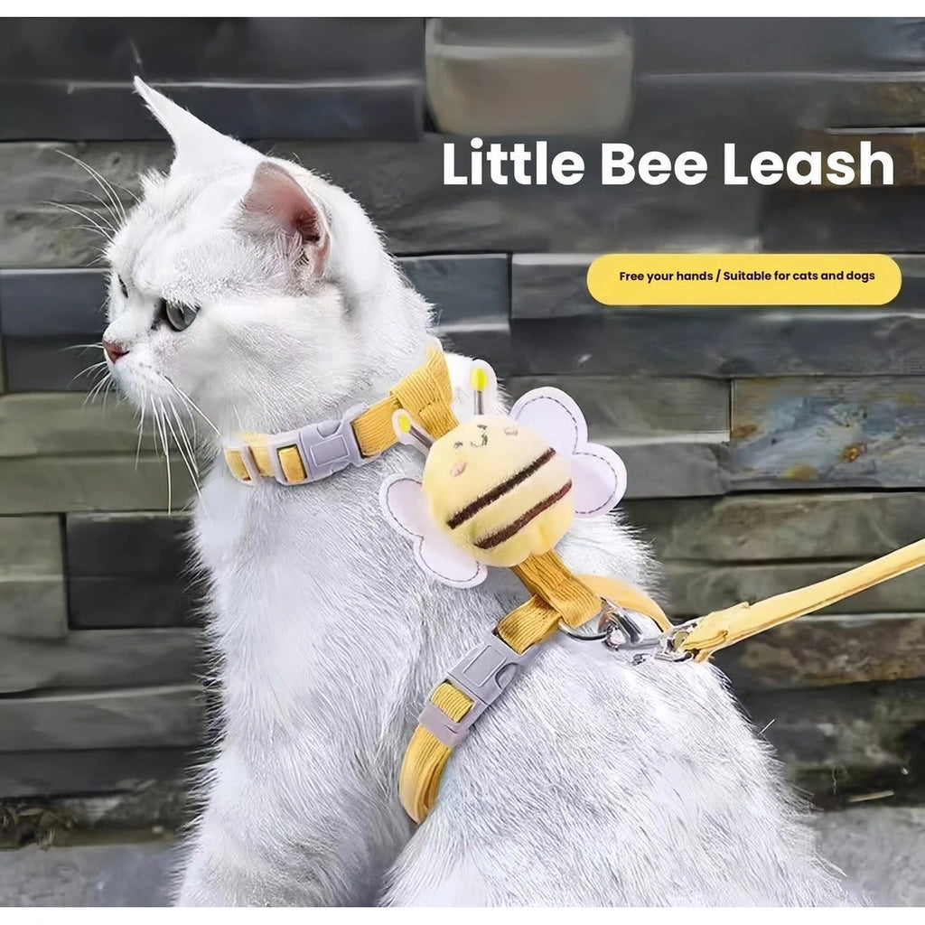 White cat wearing the yellow bee harness with matching leash attached
