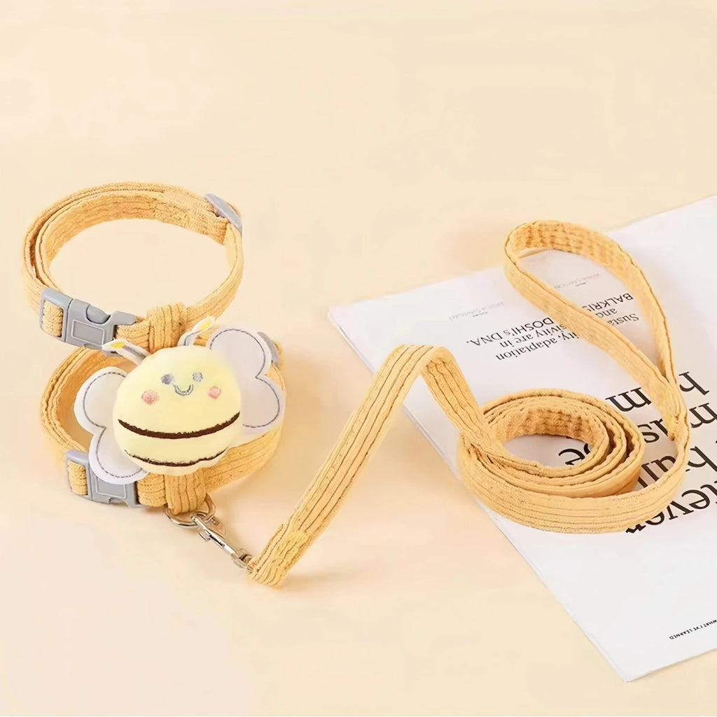 Yellow bee cat harness with matching lead laid out on a pale background
