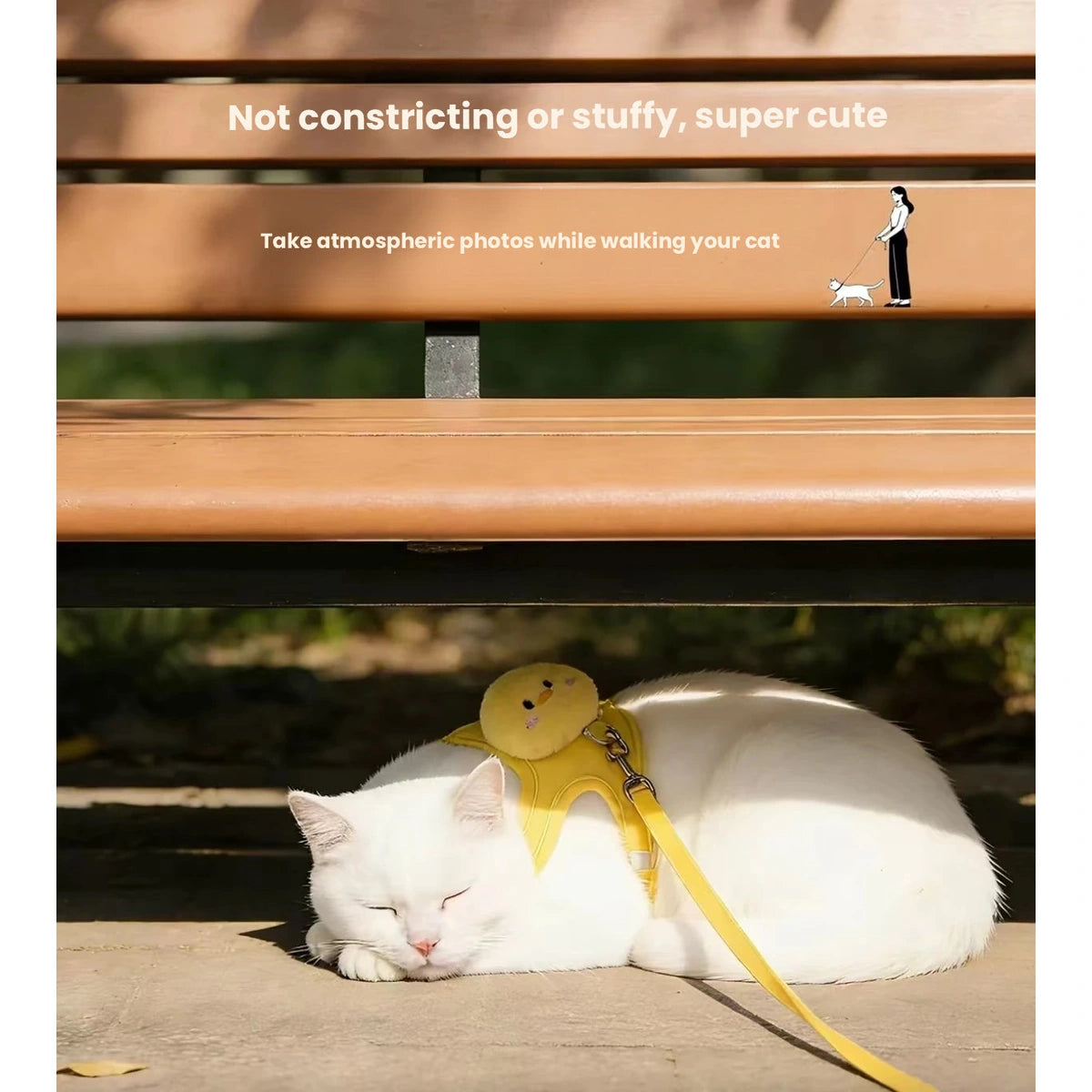 Cat in yellow harness resting under a bench