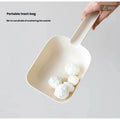 Cream Meoof cat litter scoop lifting a clump from litter