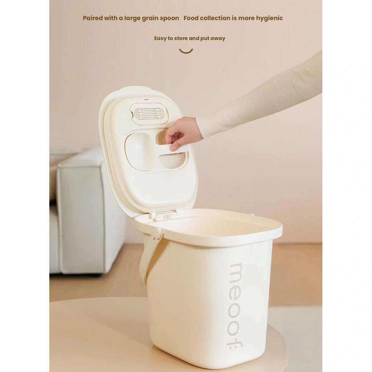 Hand opening the lid of a cream Meoof pet food bin