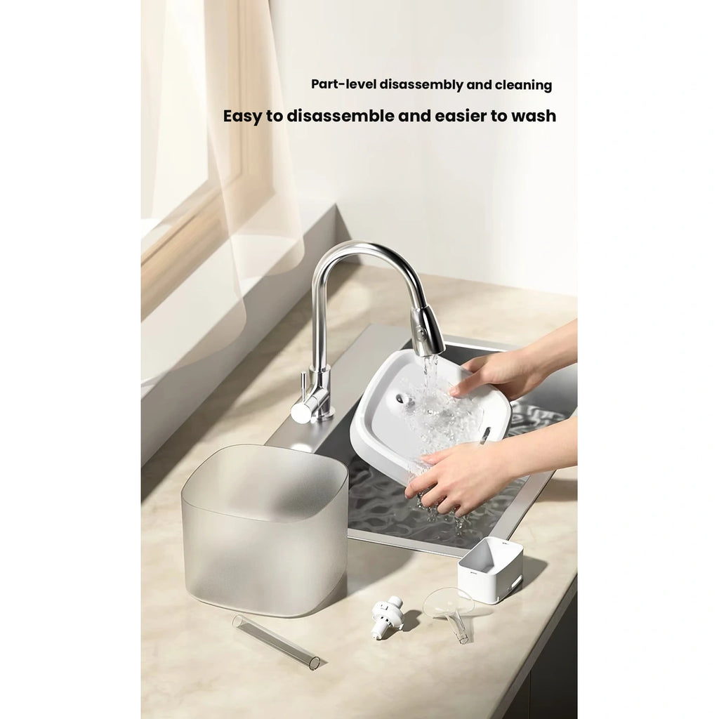 Hands rinsing removable Pawgether P900 fountain parts in a sink