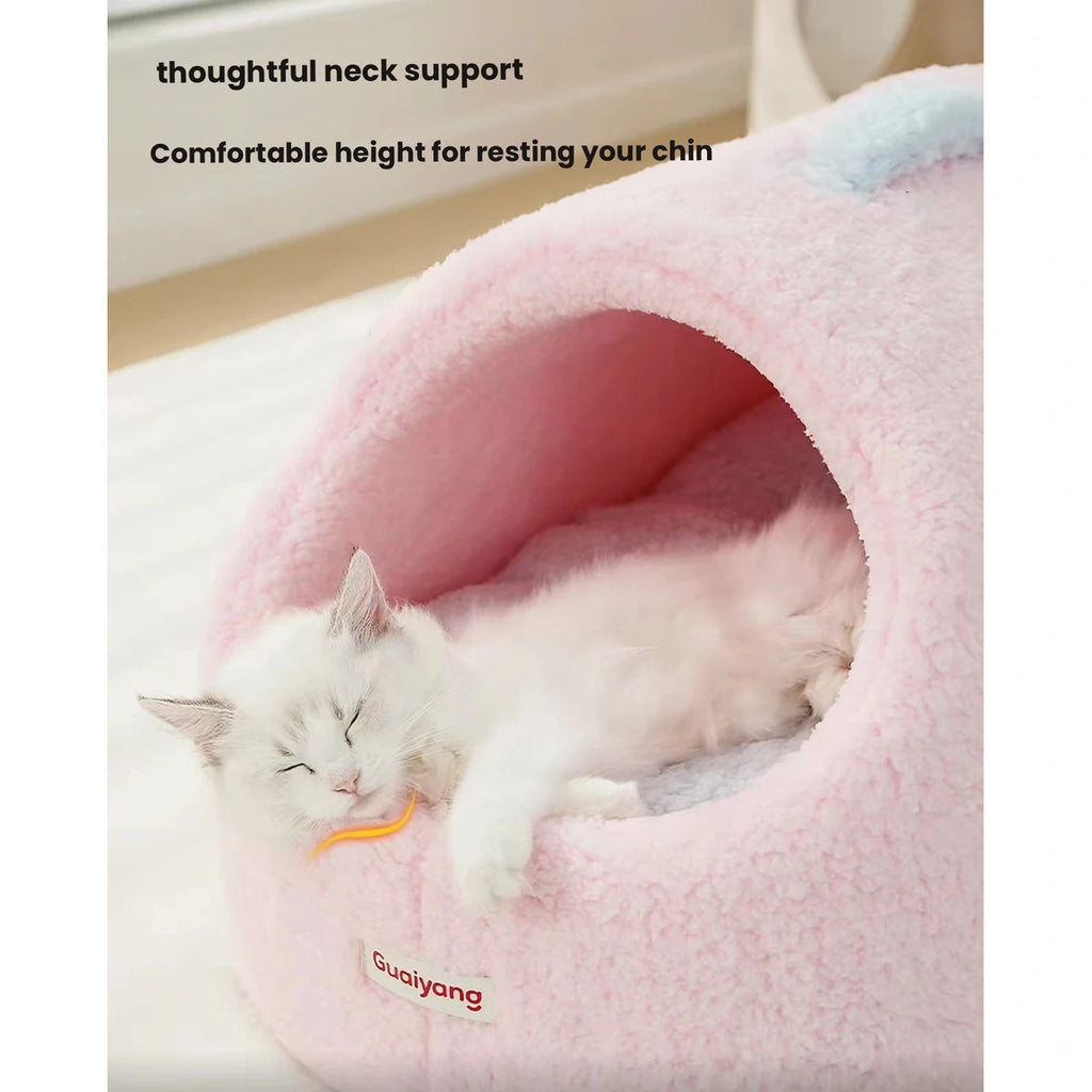 Cat resting its chin at the opening of a pink cave bed