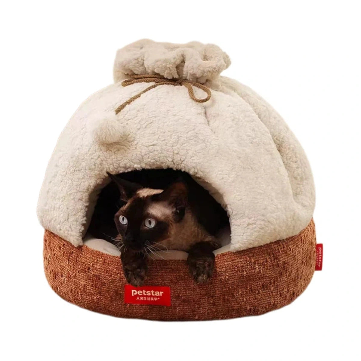 Cat in a beige Petstar plush cave bed with a brown base and pom-pom trim