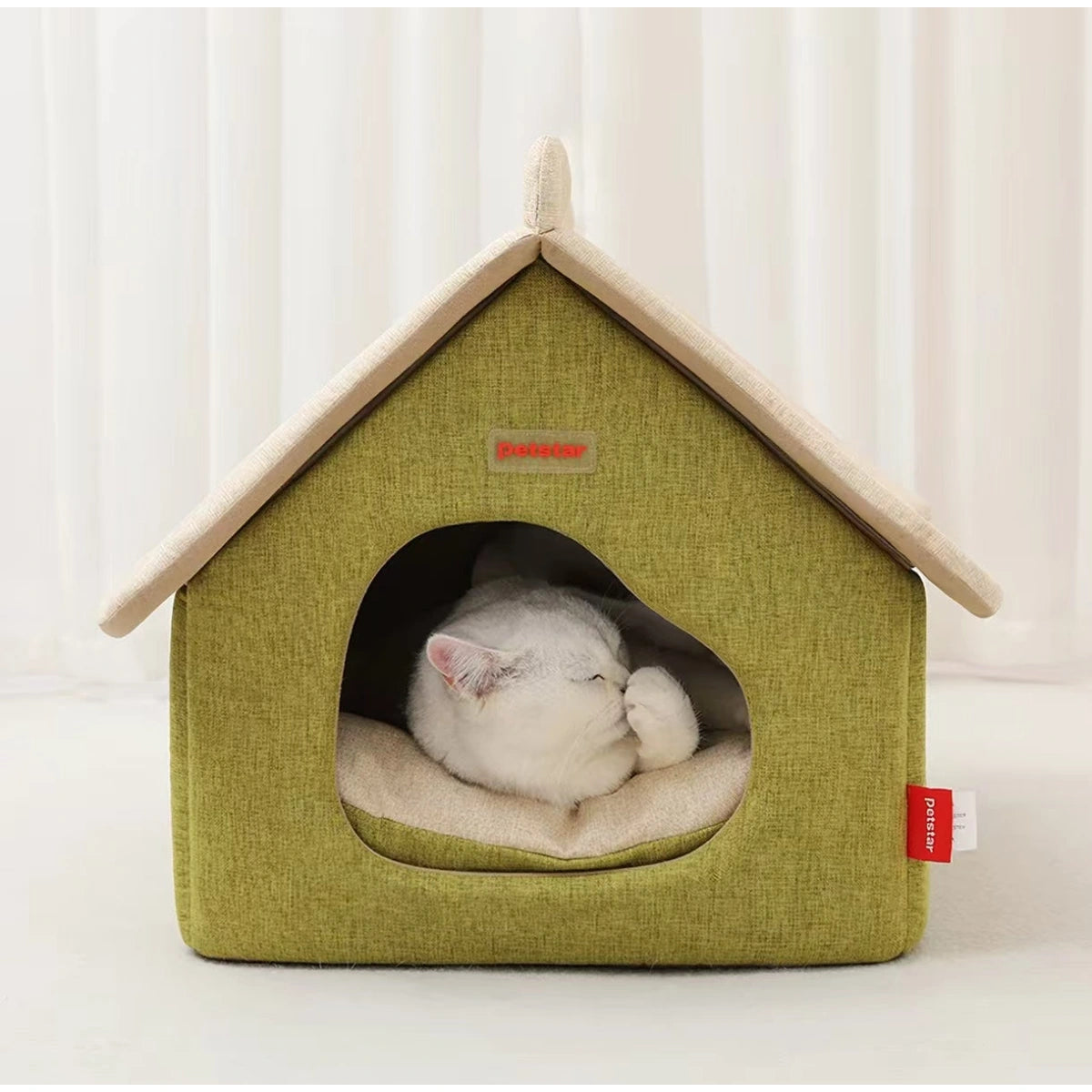 White cat resting on the inner cushion of a Petstar cat house bed