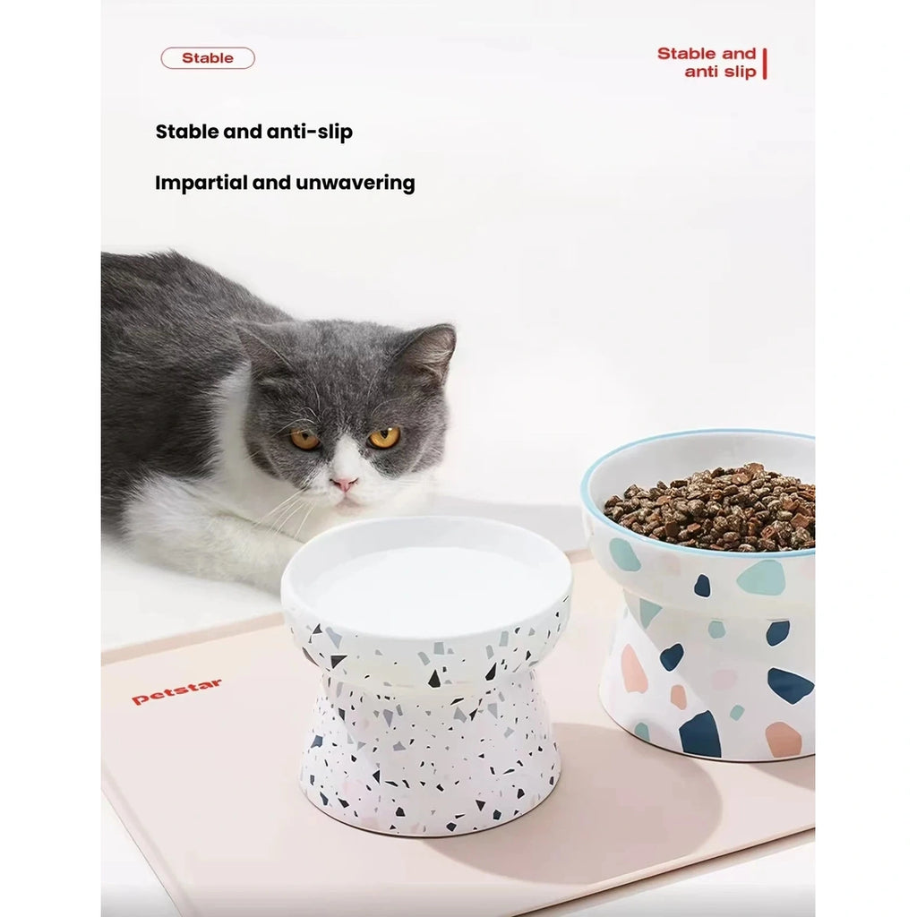 Cat eating from bowls arranged on the pink Petstar feeding mat