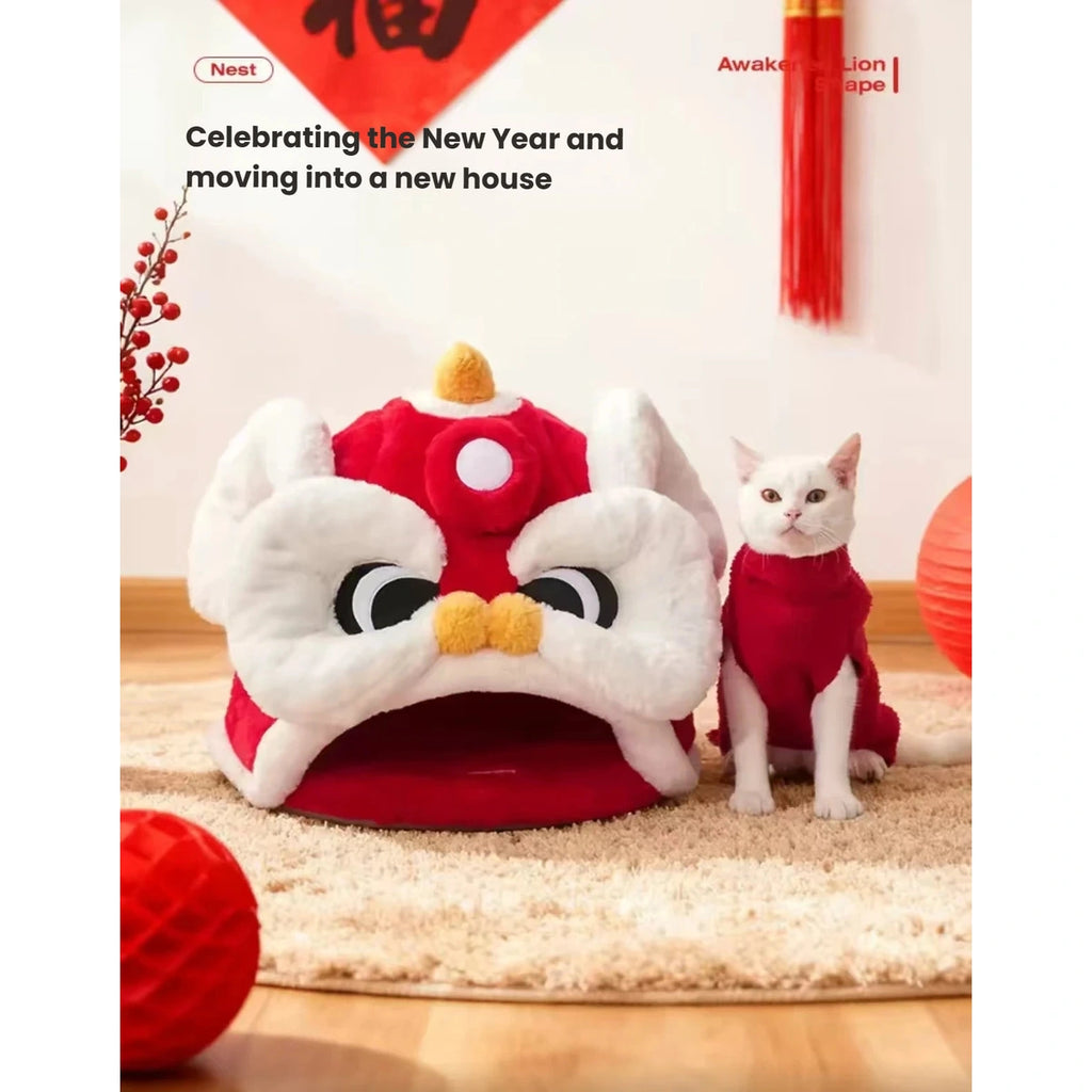 White cat sitting beside the red Lion Dance cat bed