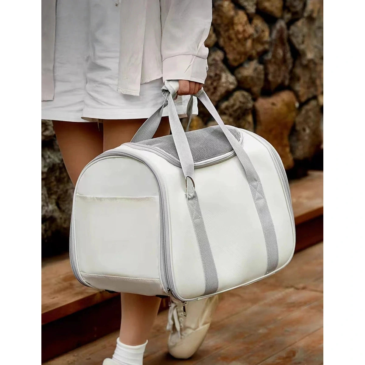 Person carrying the soft-sided cat carrier by its handles